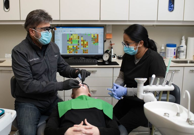 Dentist performing a dental procedure with assistant in a modern clinic setting